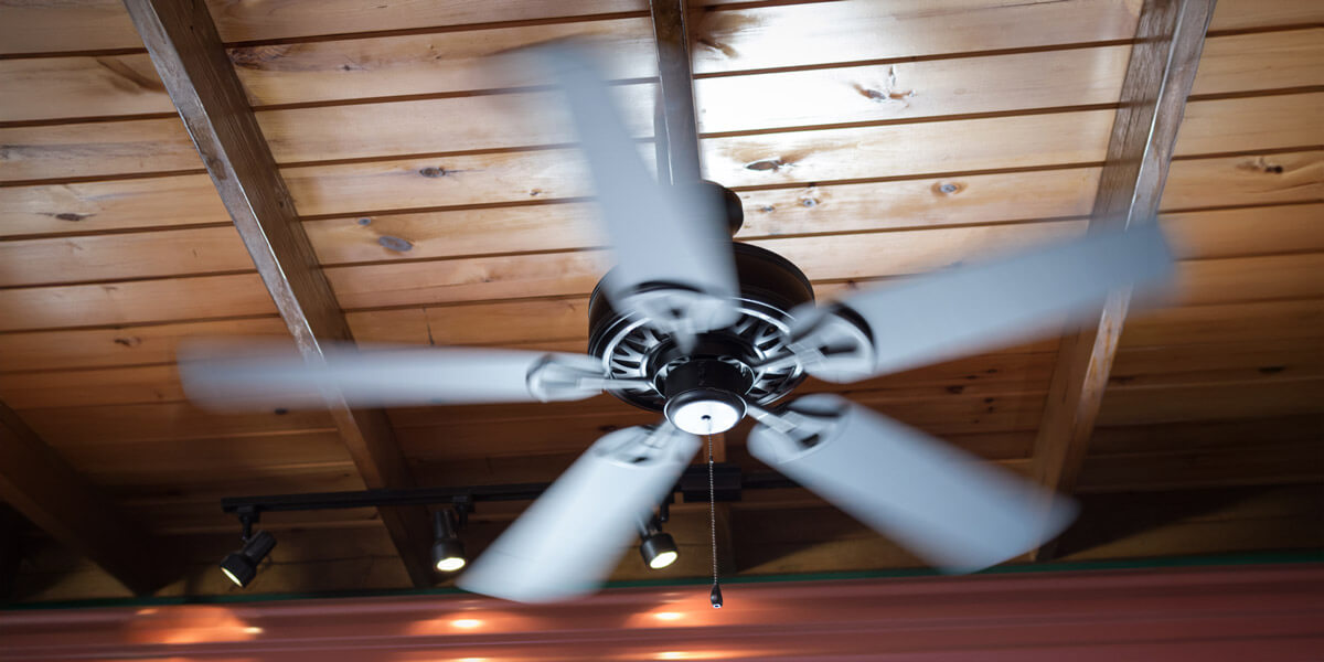 Modern ceiling fan with three blades spinning.