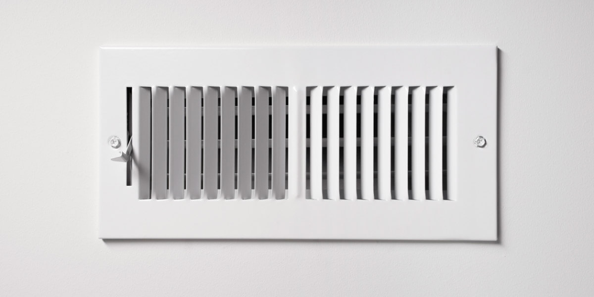 A white wall vent featuring a clean, simple vent cover, seamlessly integrated into the wall's surface.