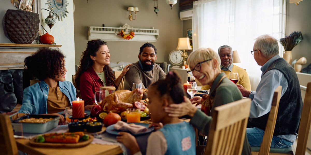 A family gathers around a table, joyfully sharing a meal featuring a beautifully roasted turkey.